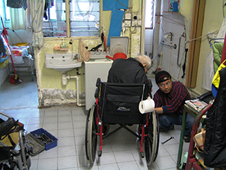 維修技師在輪椅使用者家中維修輪椅